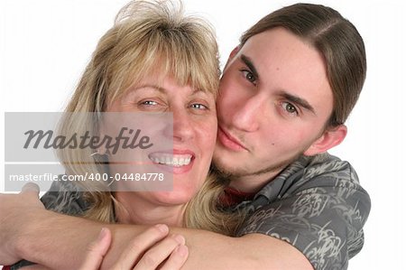 A teenaged boy kissing his mother on the cheek.