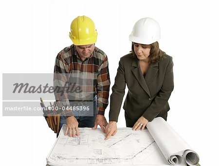 A female engineer and a building contractor reviewing blueprints.  Isolated on white.