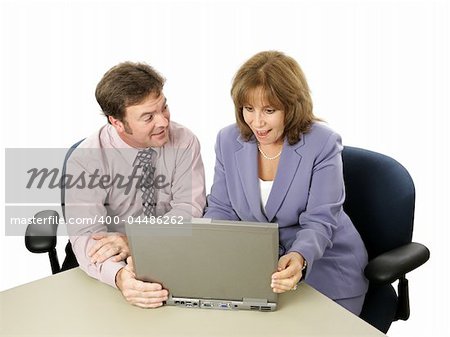 A male-female business team.  He is showing her something surprising on his laptop.