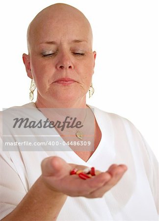 A medical patient looking at a handful of pills, reluctant to take them.