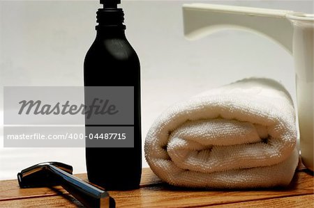 Men's Parfum with towel and shaver in a bathroom setting.