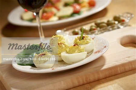 Deviled Eggs and Appetizers on a Decorative White Plate.