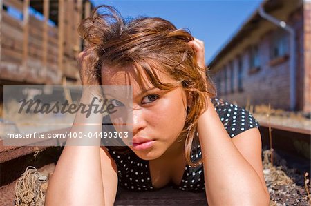 Girl in black and white dress on train tracks