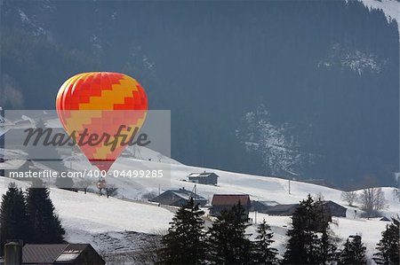 Colorful hot air balloon flying against a blue sky background