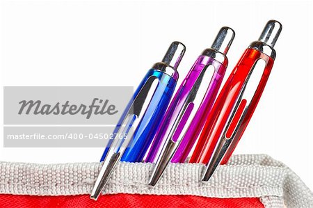 Three pens in a red pencil case over a white background