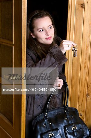 woman is standing in doorway with key in palm