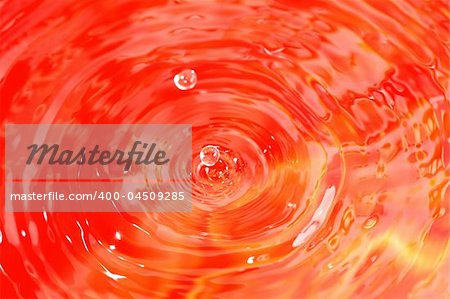 Drops of water on red rippling water background