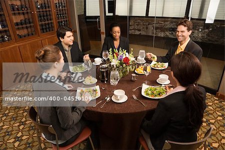 High angle of diverse group of businesspeople in restaurant eating.