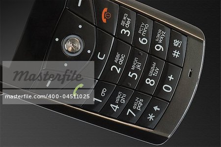 Keypad of mobile phone on the textured black background
