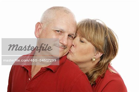 Happy middle aged man receiving a kiss from his wife.  Isolated on white.