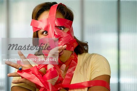 Businesswoman wrapped in red tape