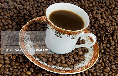 Hot drink of coffee with saucer and beans