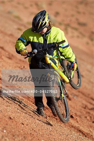 Girl on bike downhill in red canyon