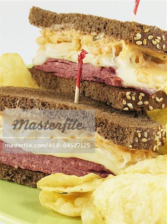 Reuben sandwich with corned beef, melted swiss cheese, sauerkraut, and thousand island dressing on pumpernickel rye bread. Served with potato chips.
