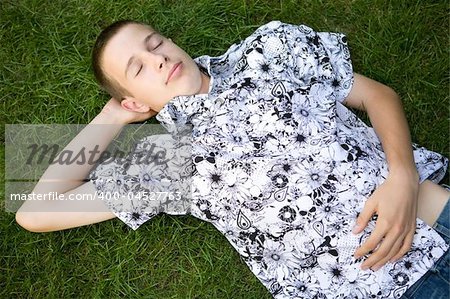 happy boy lying on grass