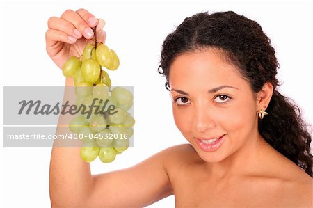 A smiling woman holds a bunch of green grapes, standing on white background.
