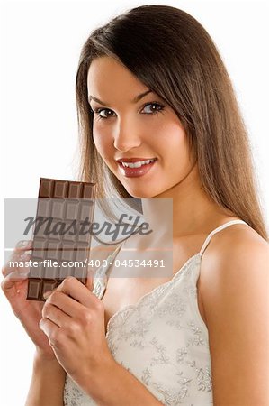 brunette in white dress showing a block of chocolate smiling