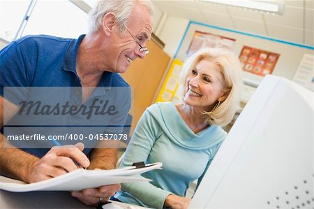 Male and female mature students working together on a computer