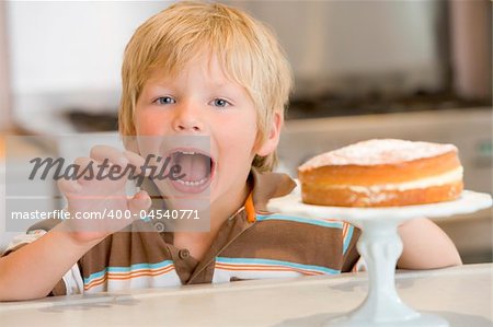 Boy grabbing at cake at home