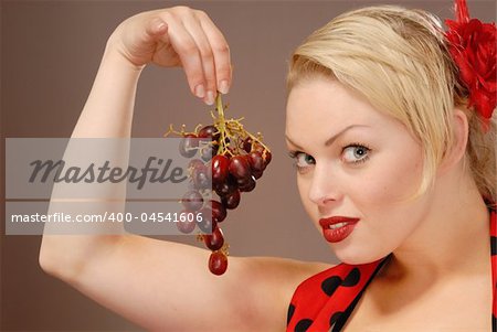 pretty girl holding red grapes to tempt you