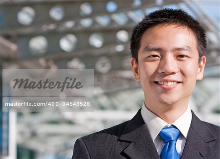Good looking asian business man standing with formal suit.
