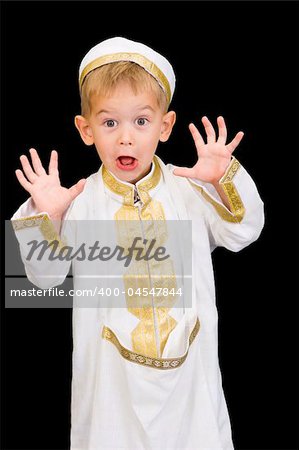 An adorable little boy dressed in Arabian thobe, isolated on black.