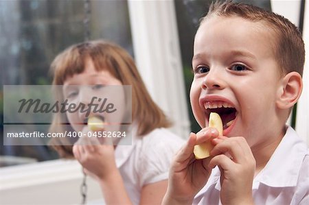 Sister and Brother Having Fun Eating an Apple