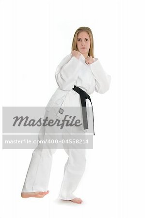 Black belt female martial artist doing low kick from the side.