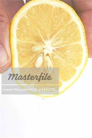hand squeezing lemon isolated against white background