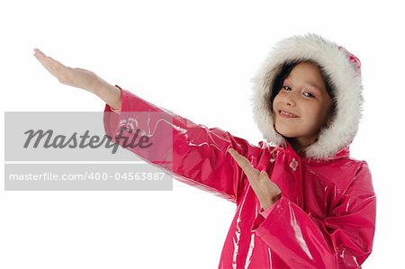 Young girl in a pink raincoat with woolly hood advertising with both hands
