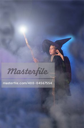 Young child in a wizard costume casting a spell.