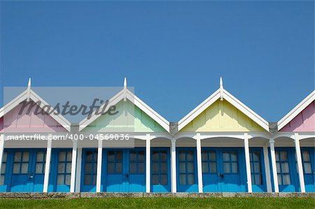 pastel beach huts against a clear blue sky