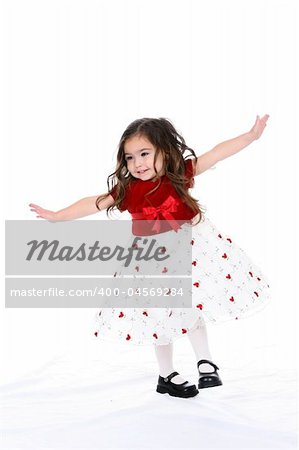 Pretty little girl with arms out as if she's pretending to be an airplane.