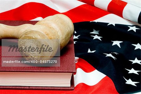 An open law book and a judges gavel on an American flag.