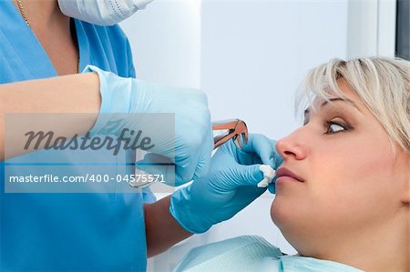 dentist at work, scared patient, tooth extraction using forceps