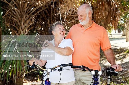 Senior couple bicycling together in the park.