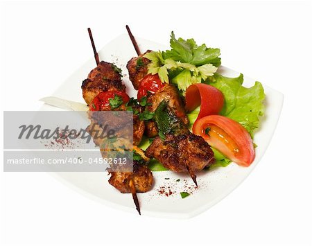 grilled meat pieces on wood sticks with vegetables