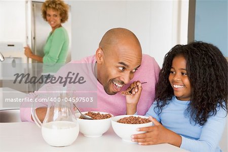 Father Sitting With Daughter As She They Eat Breakfast With Her