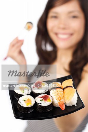 Smiling young woman presenting a plate of sushi. Shallow depth of field, focus on sushi.
