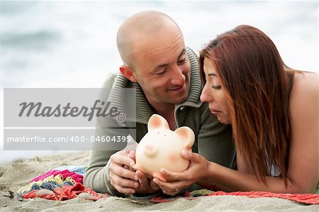 young couple holding a piggy bank