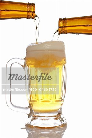 Pouring beer into mug reflected over white background