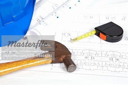 Construction plans with hard hat and tools. Shallow depth of field