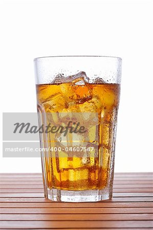 A glass of ice tea on wooden background. Shallow depth of field