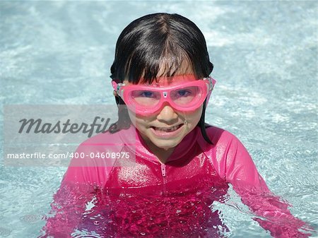 A little girl enjoys summer in the pool.