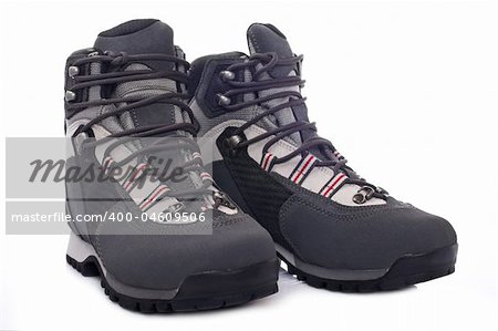 A pair of hiking boots with soft shadow reflected on white background. Shallow depth of field