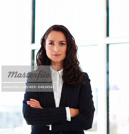 Confident businesswoman with folded arms in office