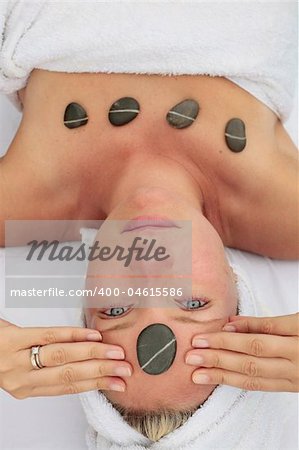 Woman at a spa with stone on her forehead
