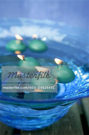 green candles over blue glass bowl of water