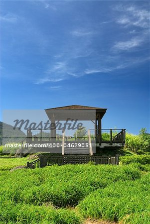 It is a pavilion on the grassland with blue sky.