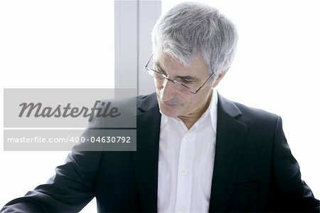 businessman senior gray hair looking down to his work desk